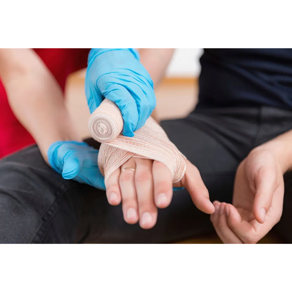 A first aider bandaging a hand